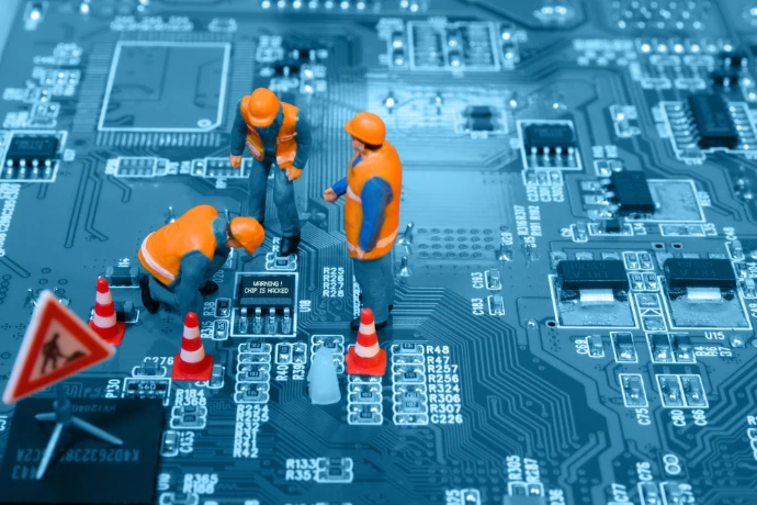 Figuras miniatura de técnicos trabajando sobre placa de circuito electrónico representando mantenimiento y soporte